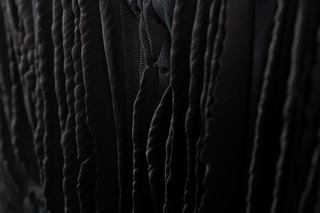 Lamella VI, hand shaped black porcelain, dyed nylon-fabric, tied, 2021
50 x 70 x 4 cm, Photo: Bjarte Bjørkum.
		